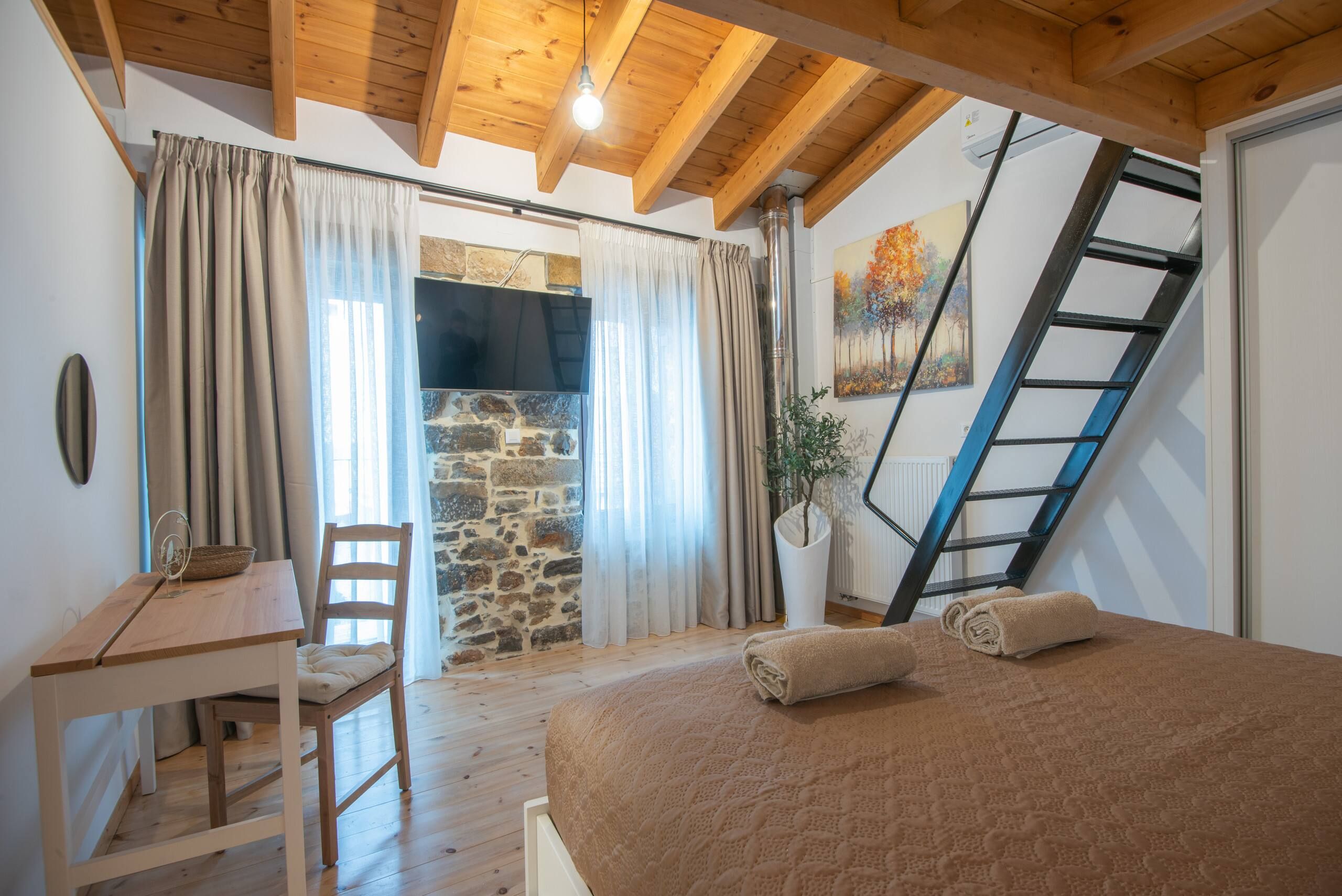 Bedroom with a desk under the wooden roof